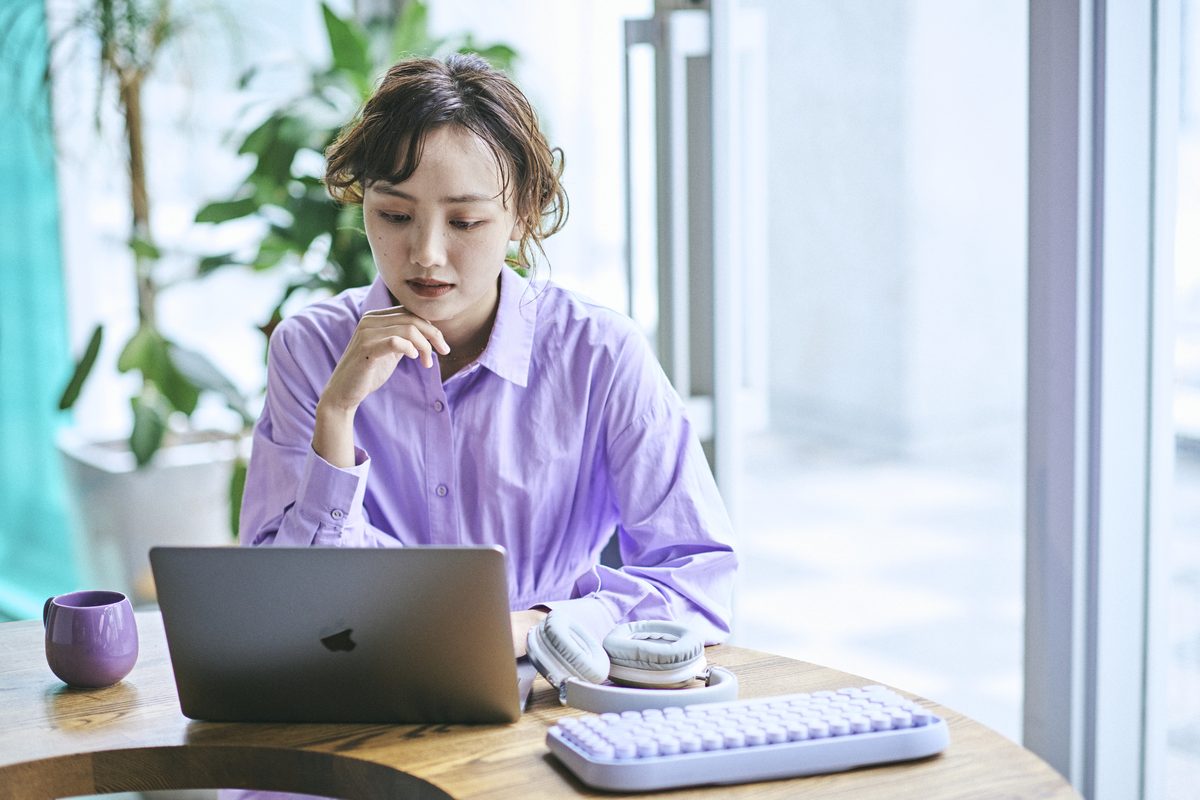 窓辺で考えごとをする女性
